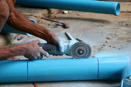 Asian workers use electric circular saw cutting the PVC pipeの写真素材