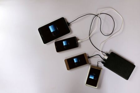 power bank rechargeable batteries attached to a mobile phone in white background.の写真素材