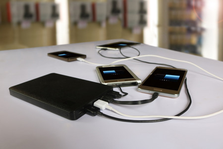 power bank rechargeable batteries attached to a mobile phone in white background.の写真素材