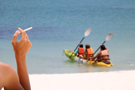 Smoking with cigarette butts ashtray on the sand on the beach and travel activityの写真素材