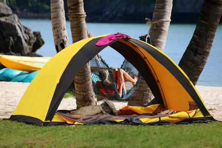 Women camping and relaxing near the tent on the coconut beach, Teen girl in bikini travel on samui island Thailand.の写真素材