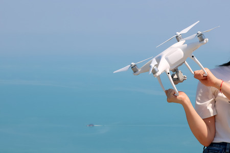 UAV or Drone camera fly up from the hands into the blue sky with ocean and island views on the...