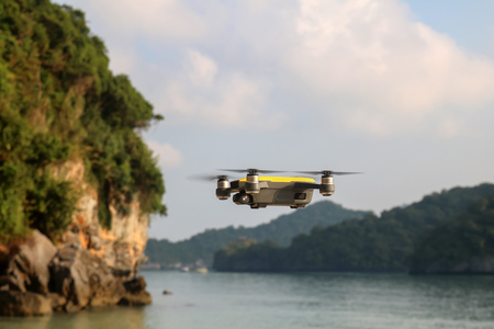 Drone camera or UAV Flying from the beach to the sky with ocean and island views backgroundの写真素材