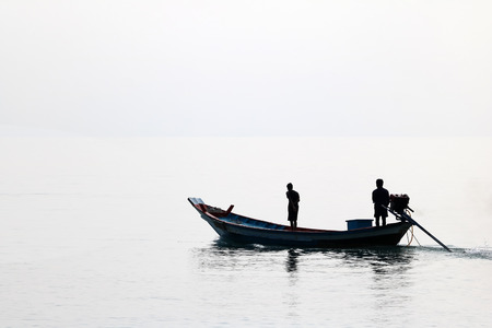 Silhouette of the long tail boat with local people while running in the sea in Thailandの写真素材
