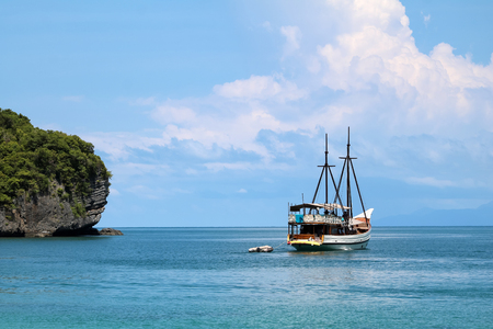 White sailboat in the ocean with views of the island and the blue sky, Gulf of Thailand.の写真素材