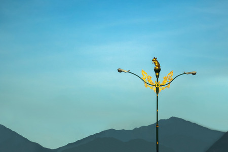 Light poles with beautiful asian-style design on the street against a blue sky in Thailandの写真素材