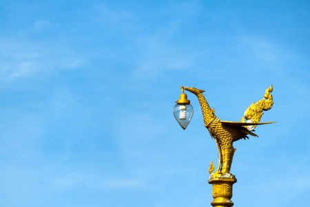 Light poles with beautiful asian-style design on the street against a blue sky in Thailandの写真素材