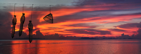 Silhouette Panorama view of the archipelago Islands, and fish trap with the red sky sunset background.の写真素材