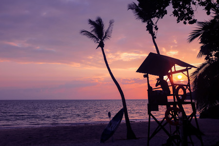 Lifeguard ready to take care of tourists on the beaches. Asian Lifeguard standing near the tower at sunrise in Thailand.の写真素材
