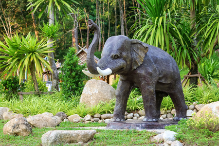Asian girl enjoying with elephant and barbarian statue in the Public park gardens.の写真素材