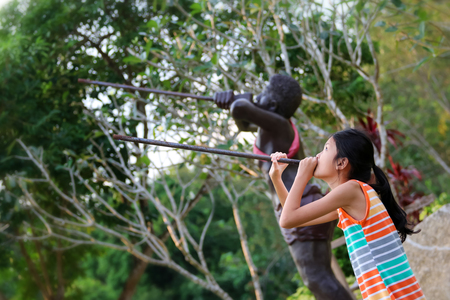 Asian girl enjoying with elephant and barbarian statue in the Public park gardens.の写真素材
