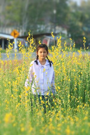 Asian school children or girls are cheerful in the flower beds in the gardens in Thailand.の写真素材