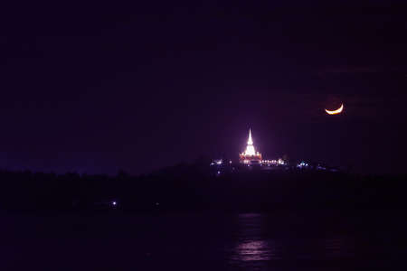 Pagoda at night with a crescent moon in the sky in Thailandの写真素材