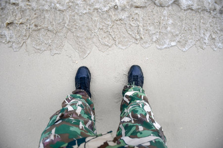 The feet of the forest rangers standing on the beach in Thailandの写真素材