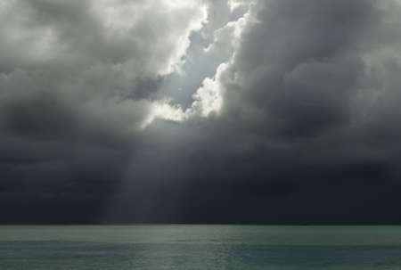The sun breaking through a storm cloud over a Maldivian Lagoonの写真素材
