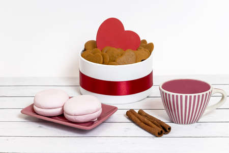 Ceramic cup, marshmallows and heart-shaped cookies on a light, wooden background. Festive serving...
