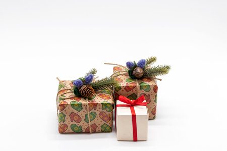 Christmas composition on a white background with gift boxes, with a red ribbon with fir branches, a copy space for your congratulationsの写真素材