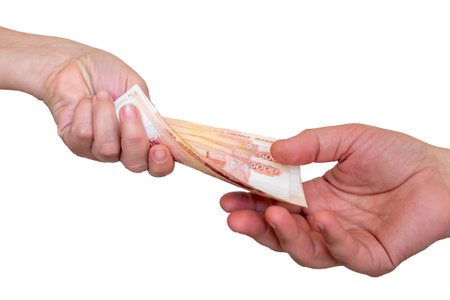 A woman's hand extends money 5000 rubles to a man's hand. From hand to hand. isolated on a white...