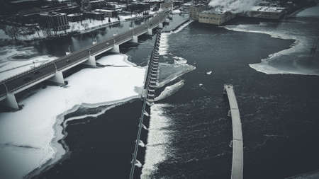 A graphite themed aerial view of city with bridge over water with ice, snow, and open reservoirs.の写真素材