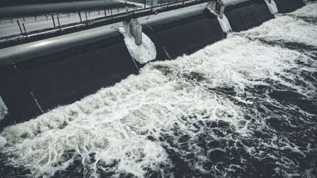 Flowing water during winter at reservoirs. Ice and snow forming around the water.の写真素材