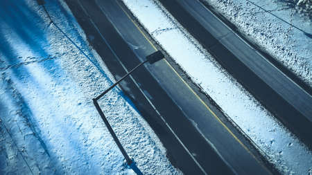 Frozen winter highway with snow covered surroundings. A chilly feel over the image.