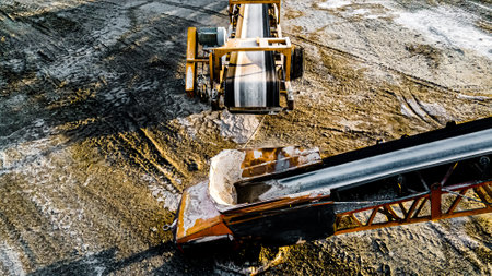 Open pit rock quarry with stone traveling on conveyors to pilesの写真素材