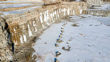 Winter snow covered open pit rock quarry in wisconsin.