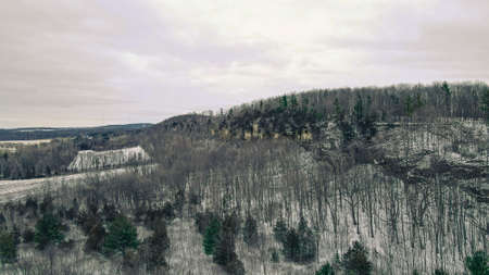 Rural scenery of a snow covered ledge with steep drop in the winter season.の写真素材