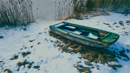 Winter season with a old abandoned boat sitting out during the season under a dusk evening environmentの写真素材