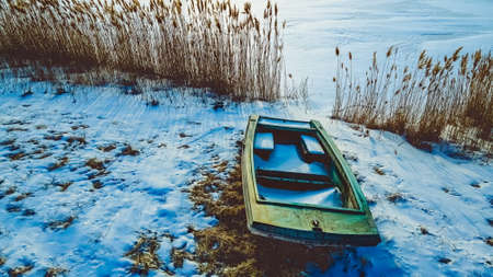 Winter season with a old abandoned boat sitting out during the season under a dusk evening environmentの写真素材