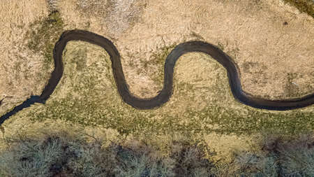 The snow has melted and springtime has arrived. This spiraling river follows a woodland.