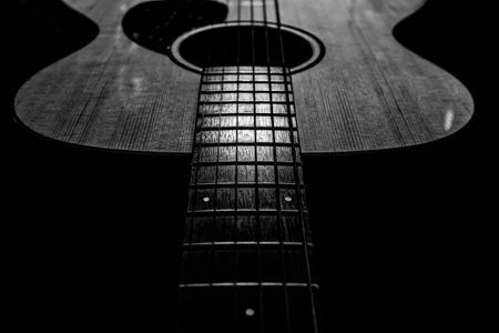 Acoustic guitar on a dark background. Black and white. Close-up.の写真素材