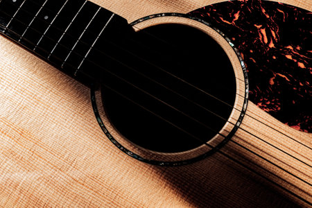 Acoustic guitar on a wooden background. Close-up. Selective focus.