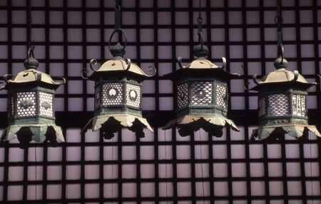 Line of old lamps. set against the wall of a temple in Japan.の写真素材