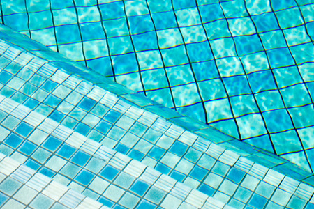 Stairs in swimming pool, Blue background.