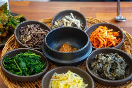 Traditional Korean Barley Rice Side Dishes Selection on Woven Tray Assortment