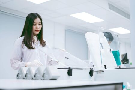 young female scientists open centrifuge in medical laboratoryの写真素材