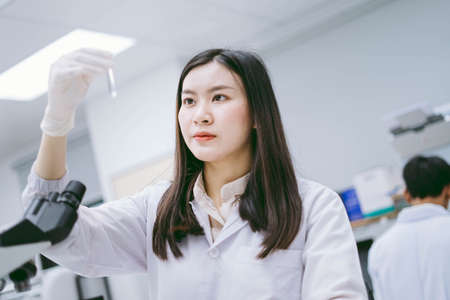 young female medical scientist looking at test tube in medical laboratoryの写真素材