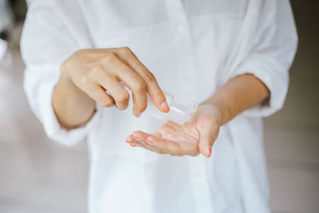 female using alcohol antiseptic gel to cleaning handの写真素材