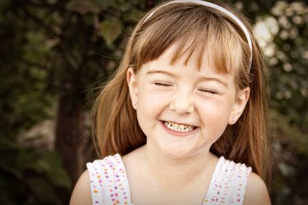 portrait of a little girl smiling with her eyes closed