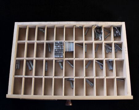 wood type drawer with metal type against a black background