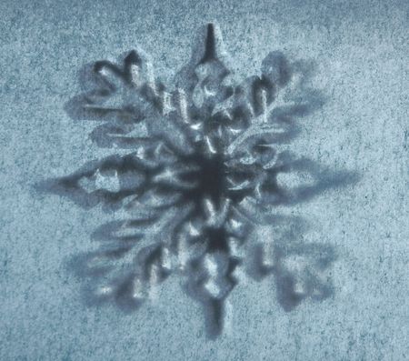 a grunge snowflake on a pale blue backgroundの写真素材