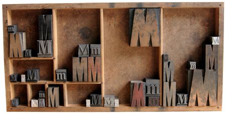 the letter M in upper and lower case and different fonts, both serif and san serif, all in a wood...