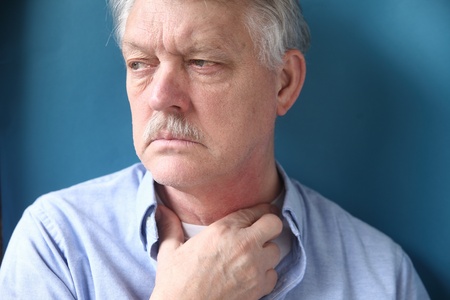 senior man with throat or neck irritationの写真素材