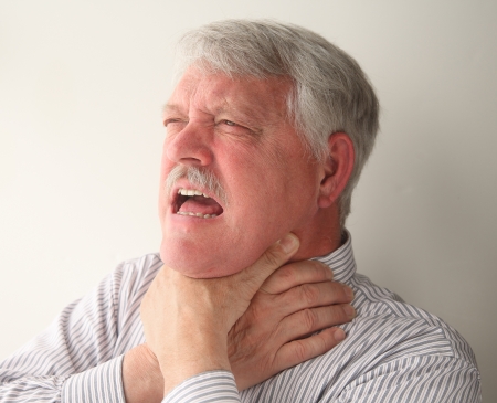 a senior man with food stuck in his throatの写真素材