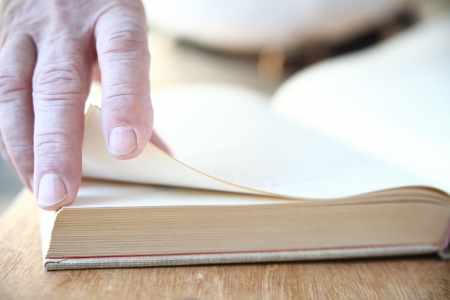 a man turns the pages of a large bookの写真素材