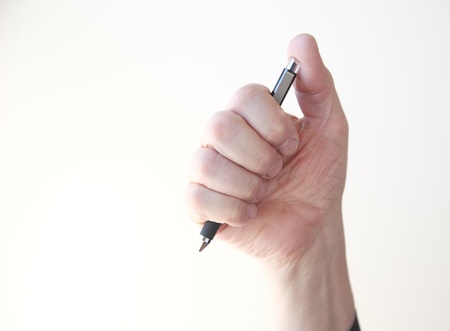 a man grasps a ballpoint pen in his hand
