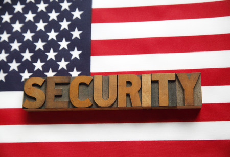 the word  security  in old wood type on a USA flagの写真素材