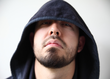 young man with dark hood hiding part of his faceの写真素材