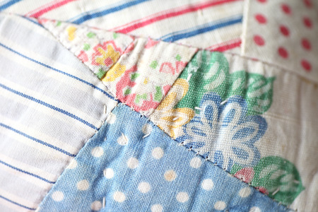 Closeup view of different fabric patterns in an old quilt